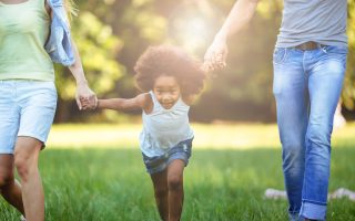 Happy young couple spending time with their daughter in nature