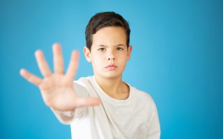 cool young boy showing number five isolated on blue background