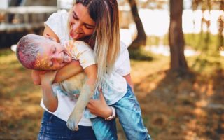 Family in a summer park. Mother in a white t-shirt. Cute little boy with paints on his face
