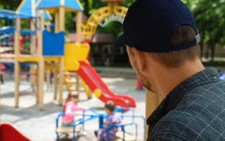 Suspicious adult man spying on kids at playground, space for text. Child in danger