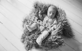 newborn baby wrapped in a blanket sleeping in a basket. concept of childhood, healthcare, IVF. Black and white photo