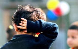 Child looking down, showing signs of emotional struggle