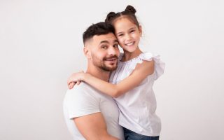 Happy family. Cheerful father and daughter embracing, studio portrait, panorama with free space