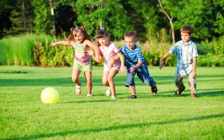 Kids group playing with ball in the backyard