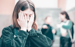 Girl being bullied at the school. Educational school isolation and bullying concept.