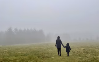 Overwhelmed mom holding child while walking away