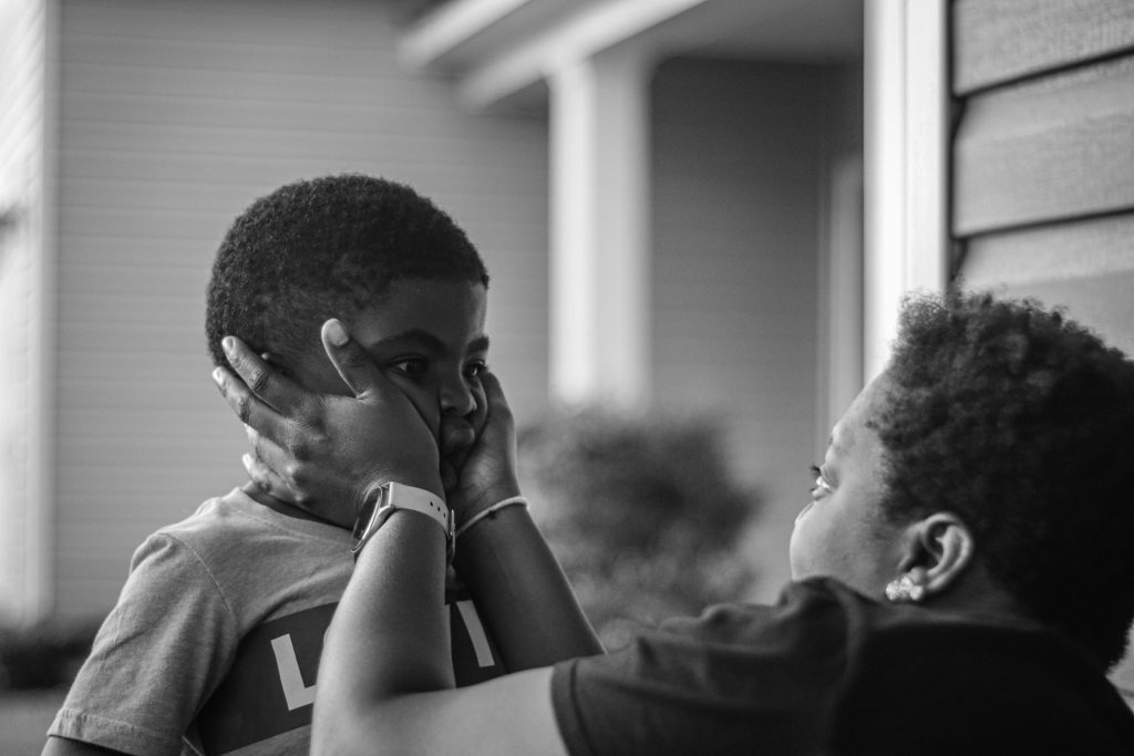 mom squeezing her son's cheeks