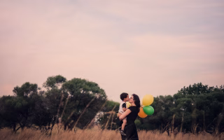 Mom hugging child with balloons