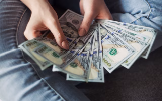 Hands holding hundred-dollar bills