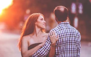 Couple embracing outdoors at sunset.