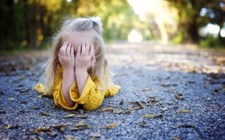 Child covering ears, showing signs of emotional overload.