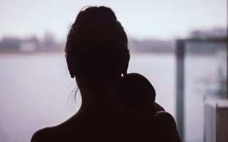 Woman standing alone, deep in thought about motherhood