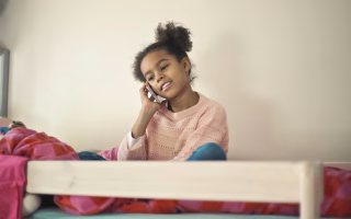 Child on a phone, underscoring the importance of knowing contact details.