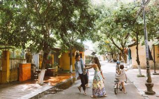A family enjoying a tree-lined street, symbolizing a kid-friendly neighborhood.