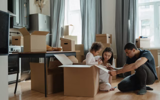 Family organizing boxes together in a new home