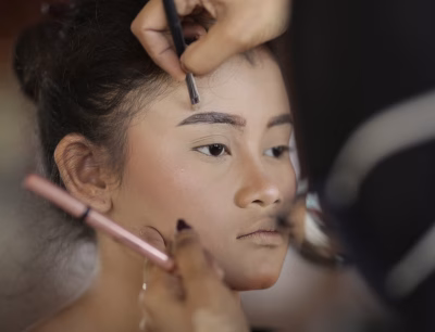 Girl getting makeup done, referencing psychologist-approved age.
