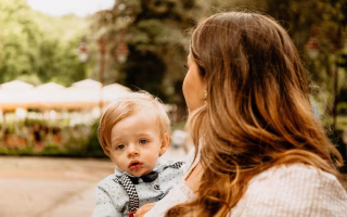 Mother holding her baby outdoors.