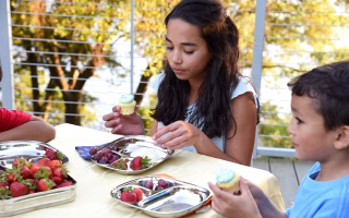 Kids enjoying fruit and cupcakes, exploring their own diet choices