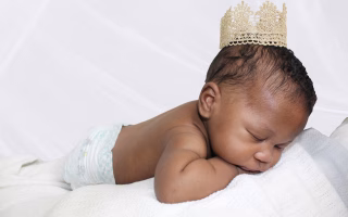 Baby wearing a crown, symbolizing queenly names