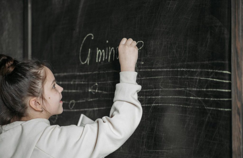 Girl Writing On Blackboard