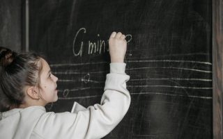 Girl Writing On Blackboard